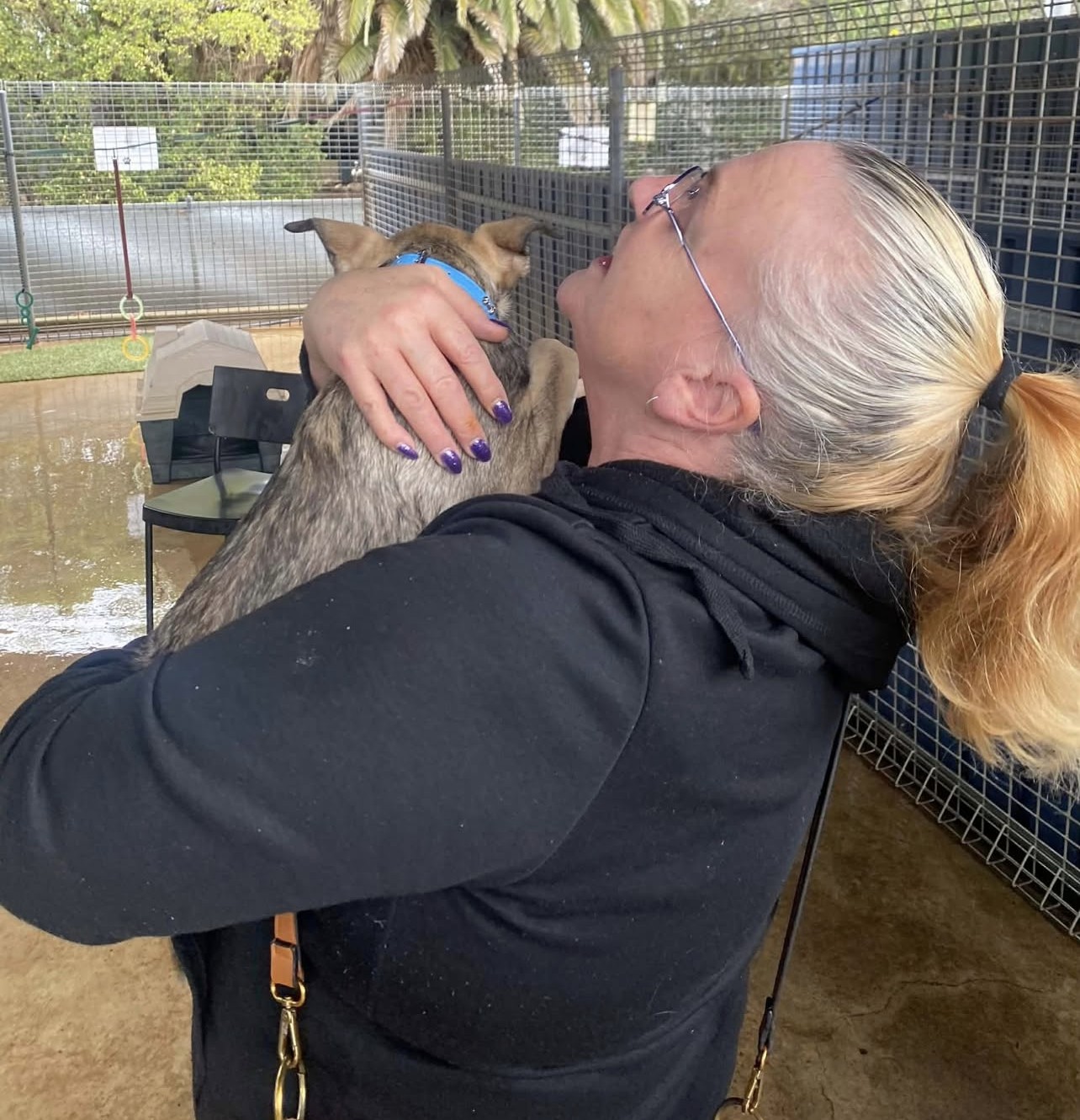 Katrina hugging a small puppy during a community visit